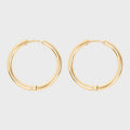 Gold hoop earrings on a light gray background