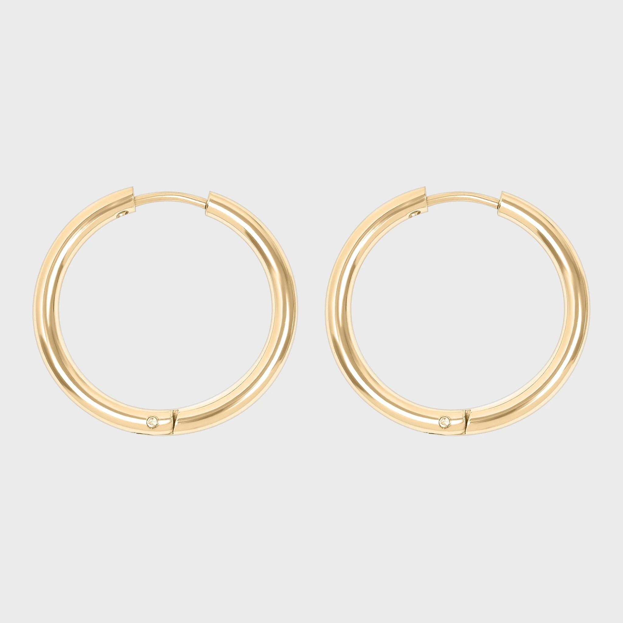 Gold hoop earrings on a light gray background