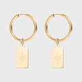 Gold hoop earrings with star-shaped charms on a light gray background
