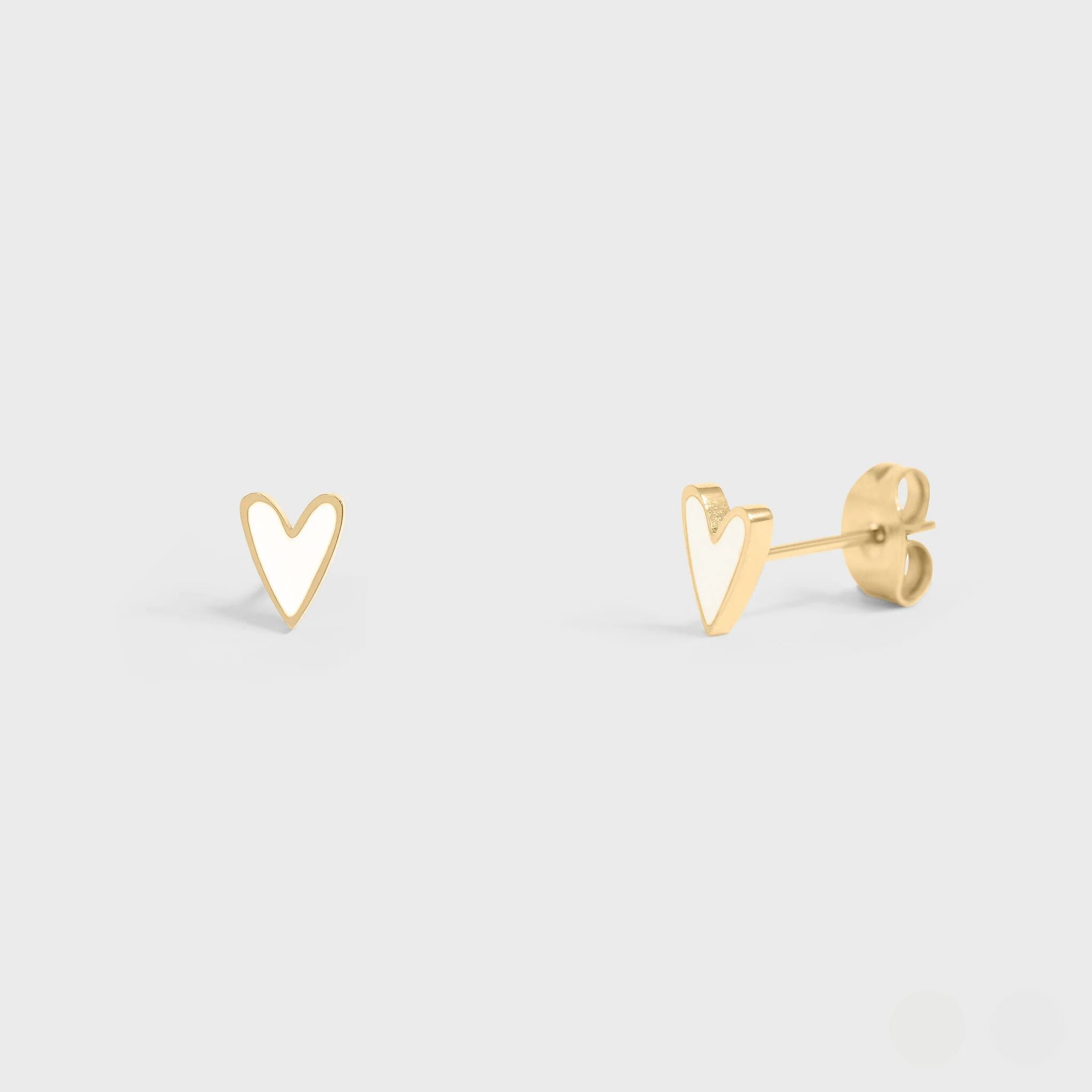 Gold heart-shaped earrings on a light gray background