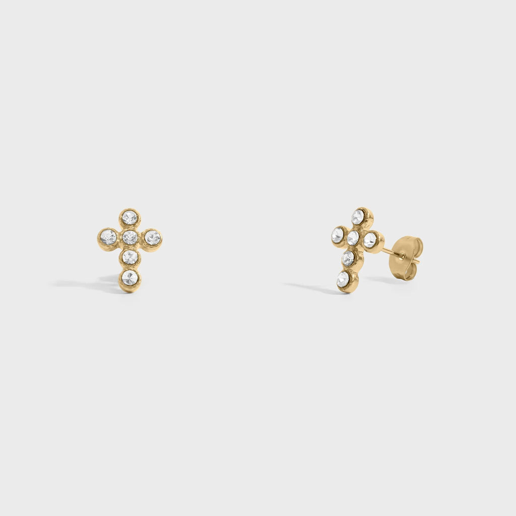 Gold cross-shaped earrings with small stones on a light gray background