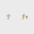 Gold cross-shaped earrings with small stones on a light gray background