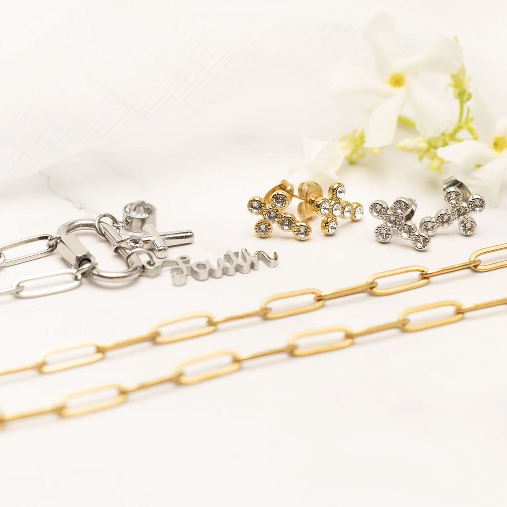 Gold and silver chain necklaces with pendants and earrings on a white background