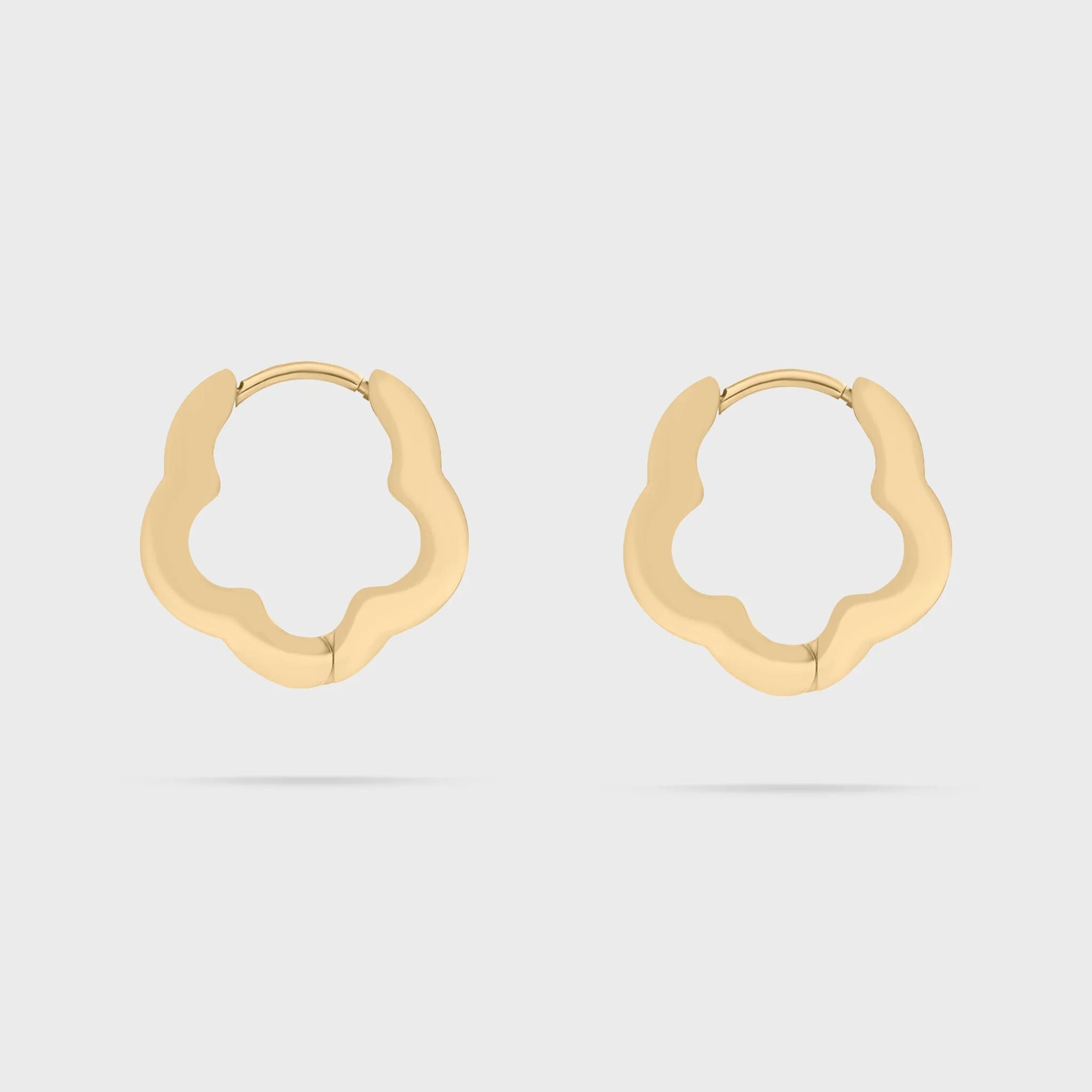 Gold floral hoop earrings on a light gray background