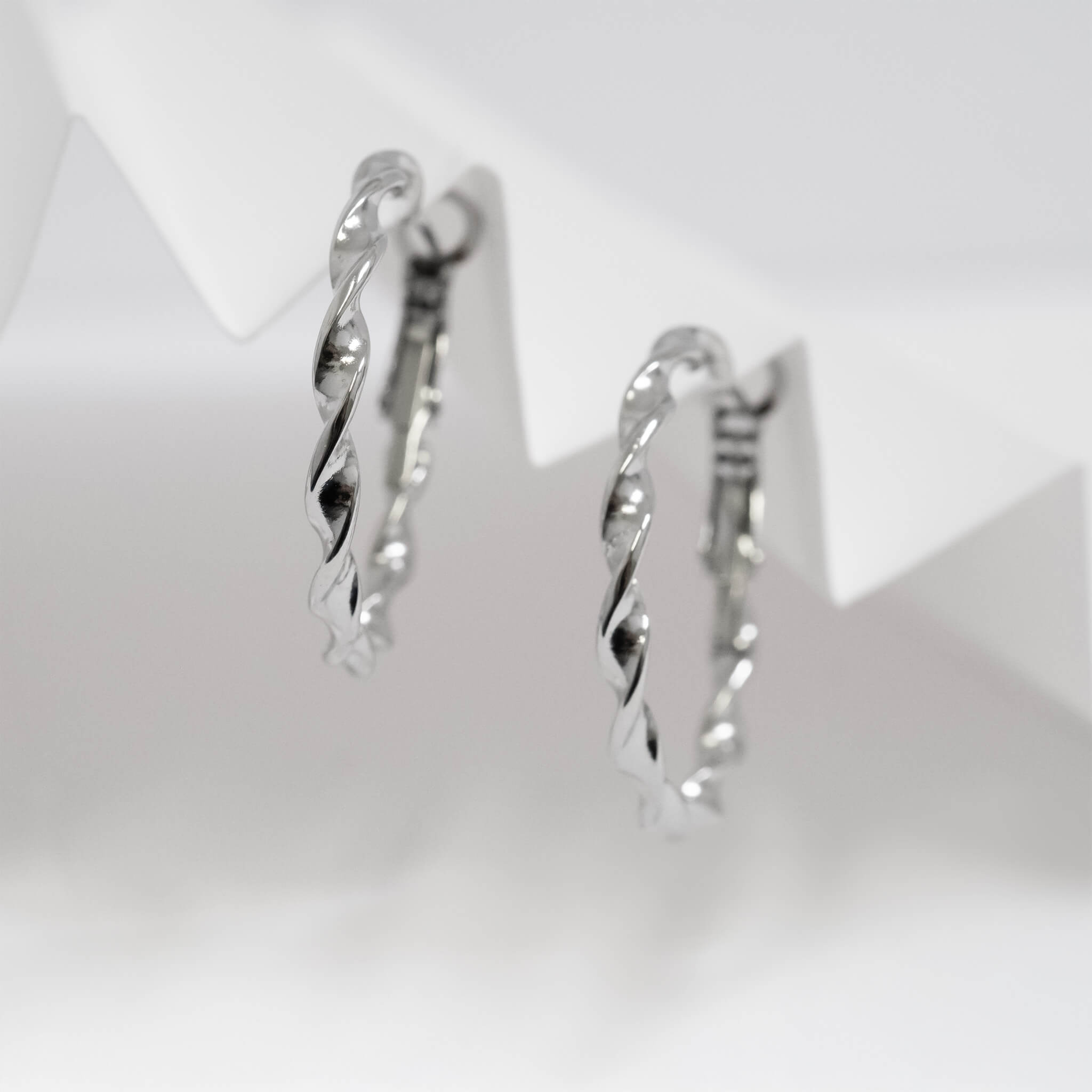 Silver hoop earrings on a light gray background