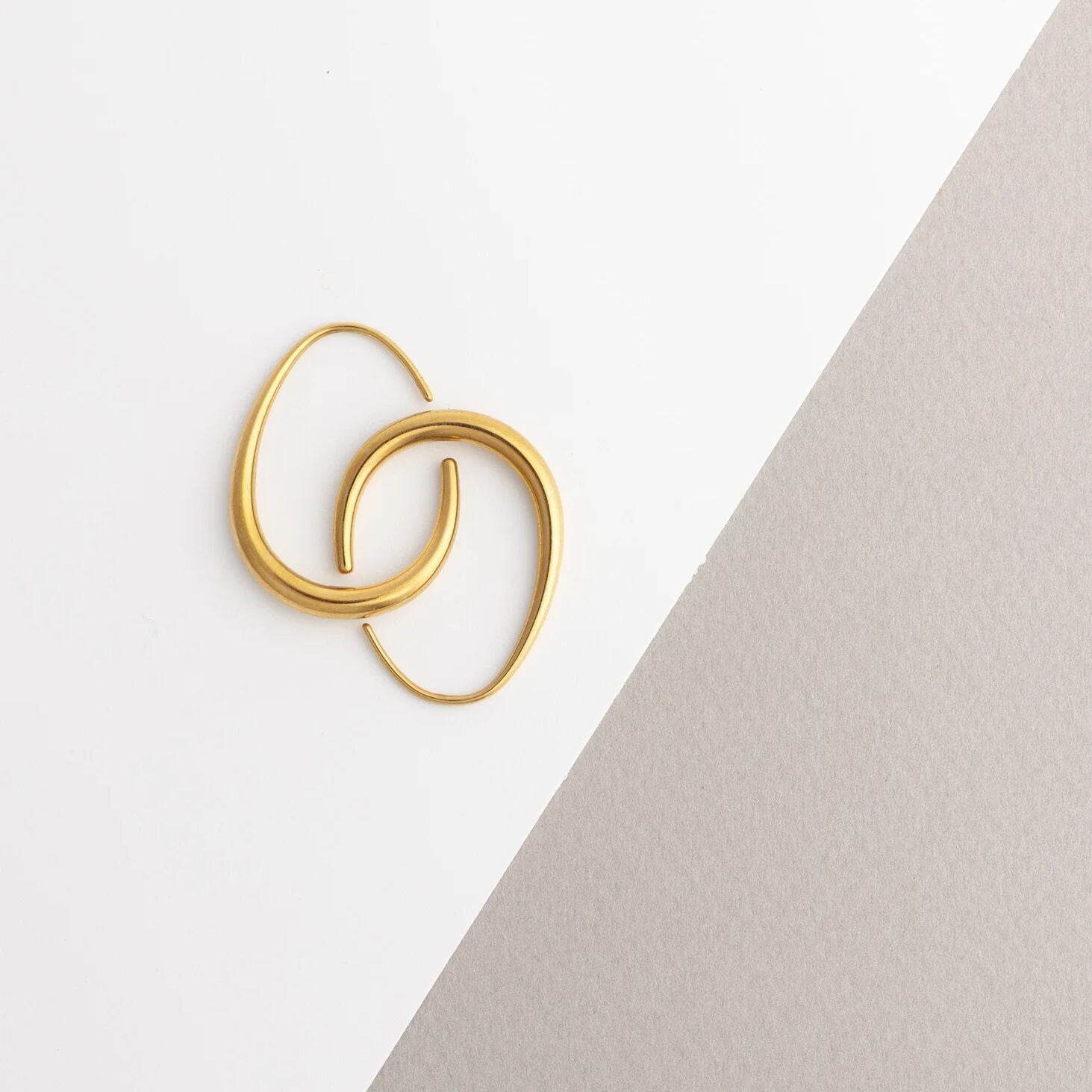 Gold hoop earrings on a light gray background