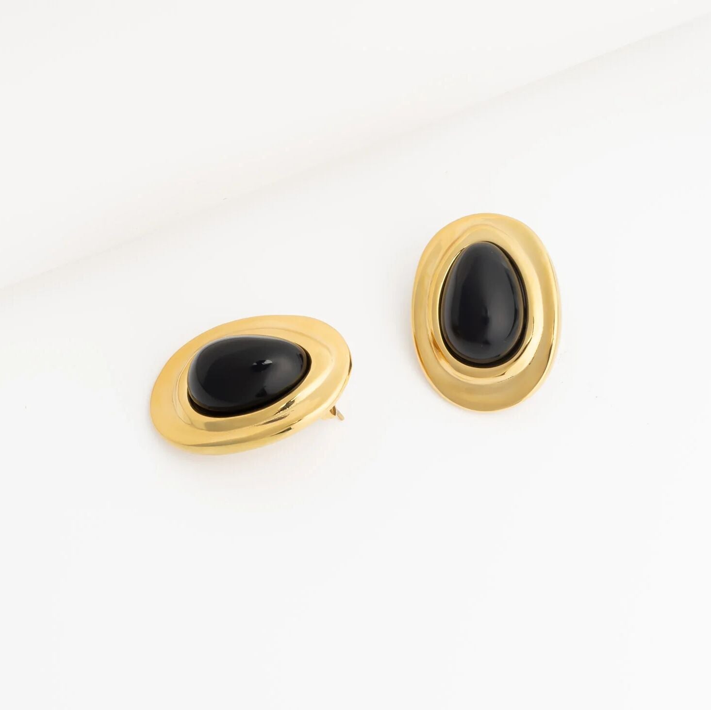 Pair of gold Black Enamel Stud Earrings with black stones on a white background