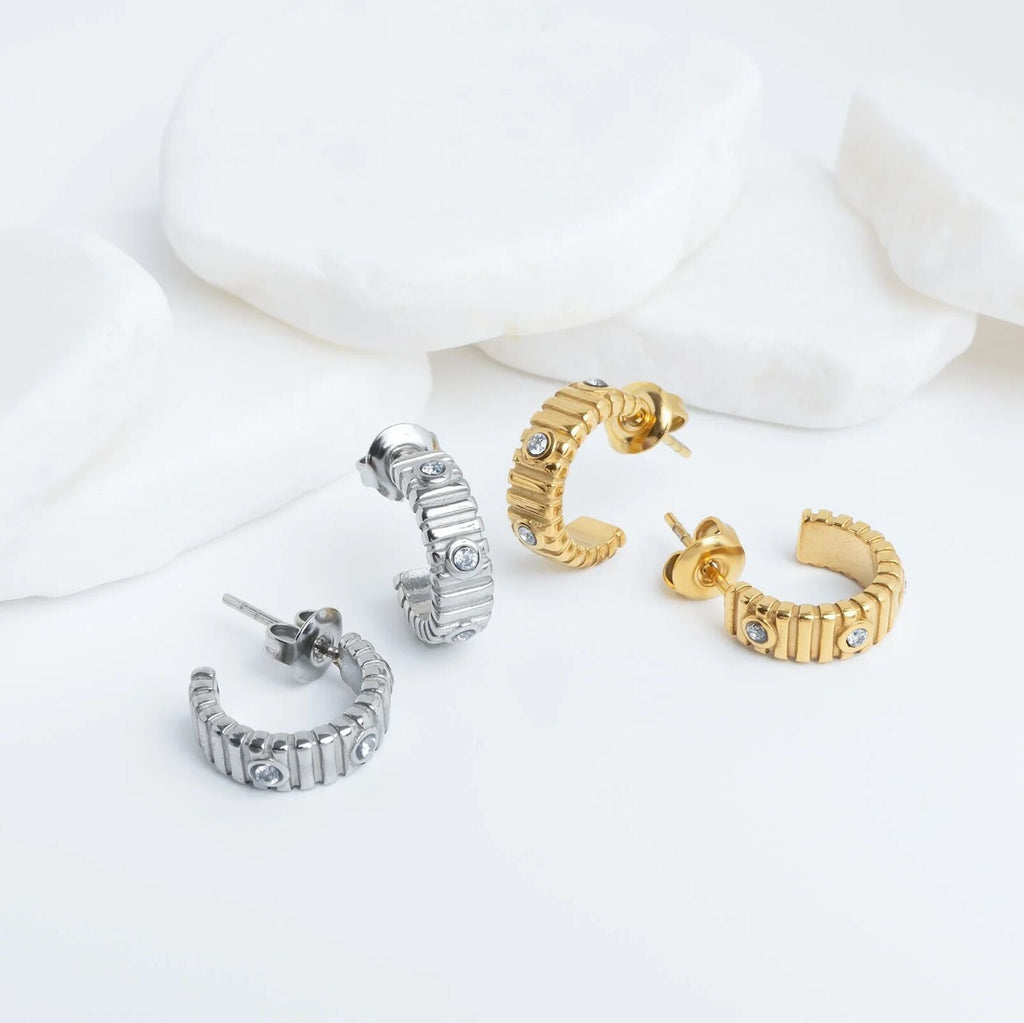 Set of gold and silver hoop earrings on a white background