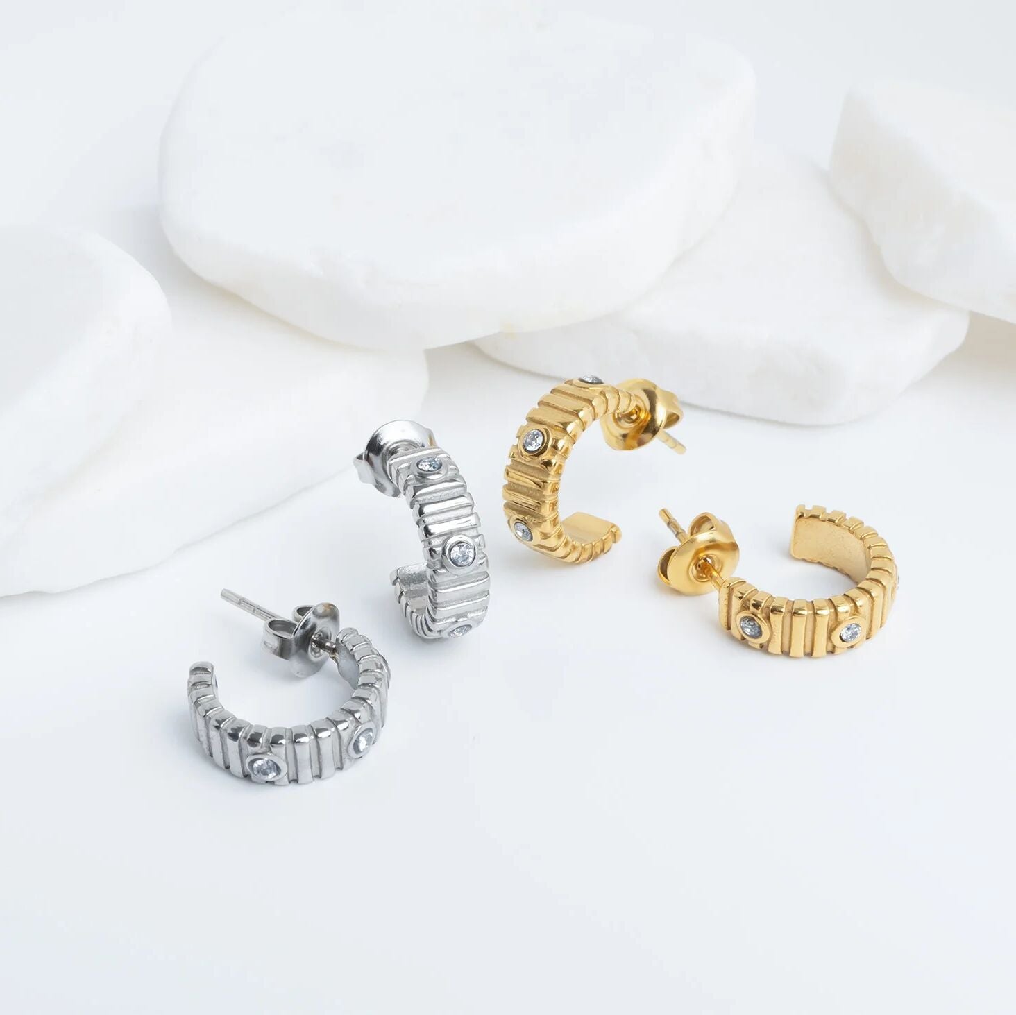 Set of gold and silver hoop earrings on a white background