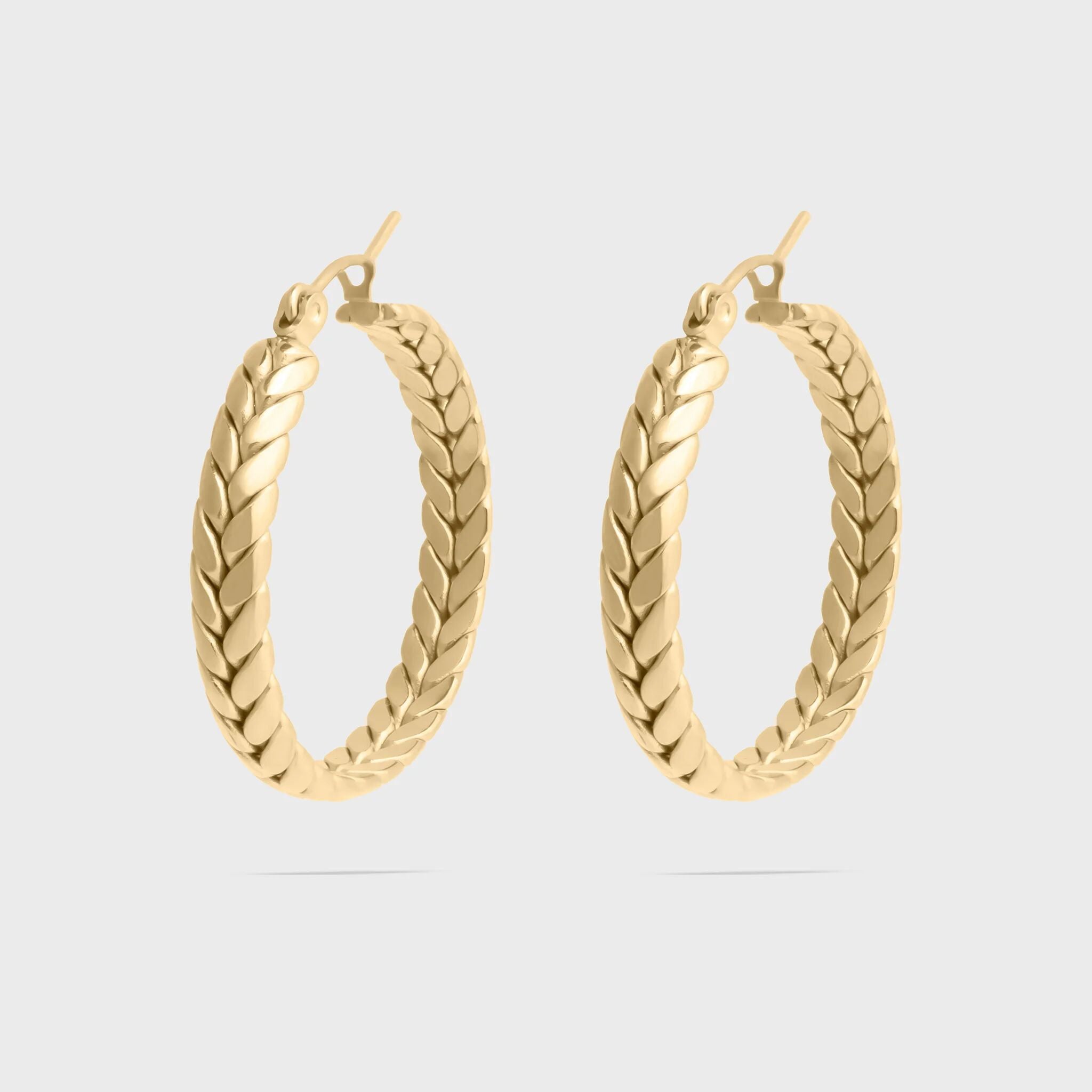 Gold hoop earrings on a light gray background