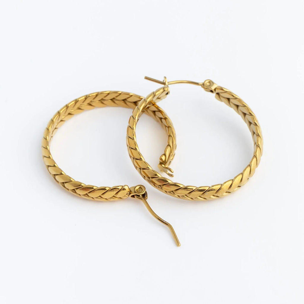 Gold hoop earrings with braided design on a white background