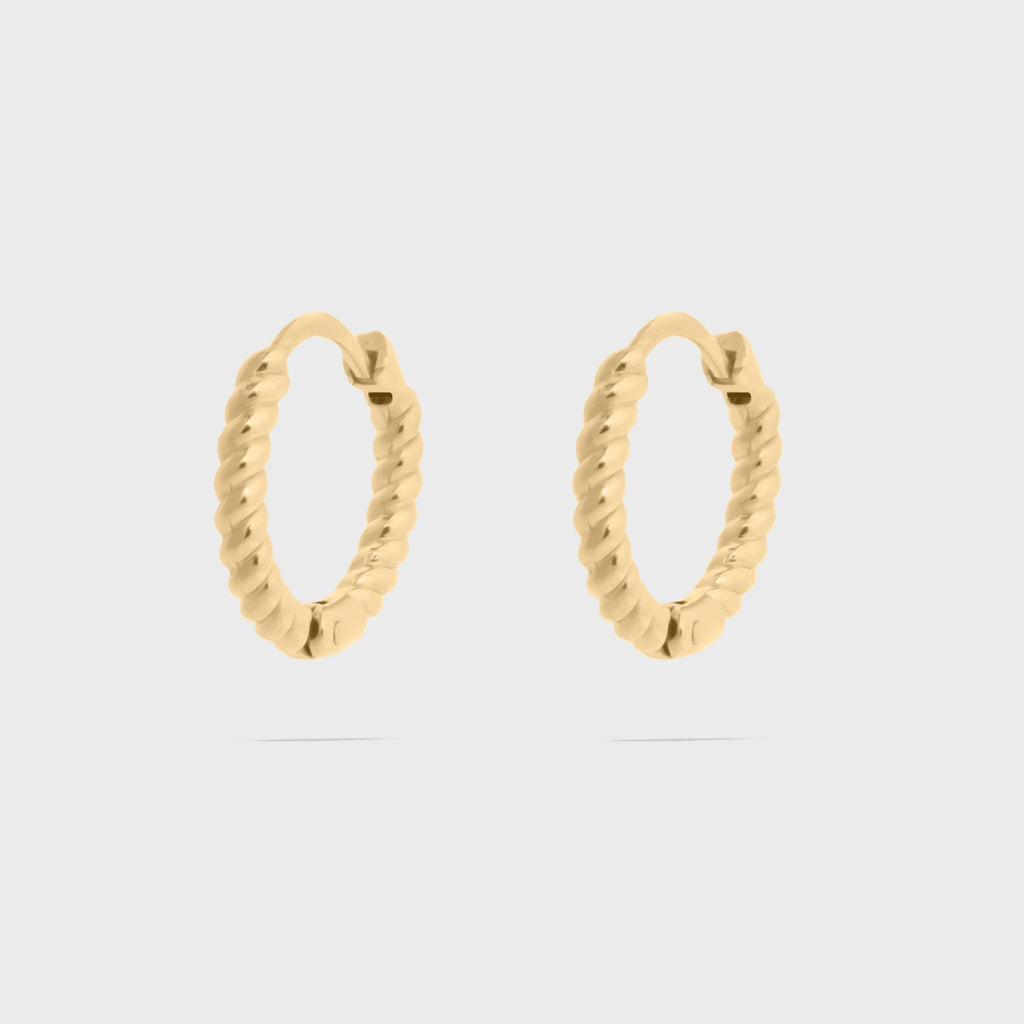Gold hoop earrings on a light gray background
