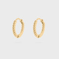 Gold hoop earrings on a light gray background