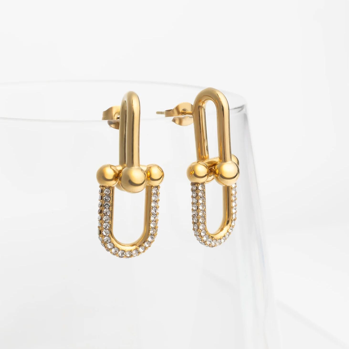 Gold hoop earrings with embedded stones on a white background