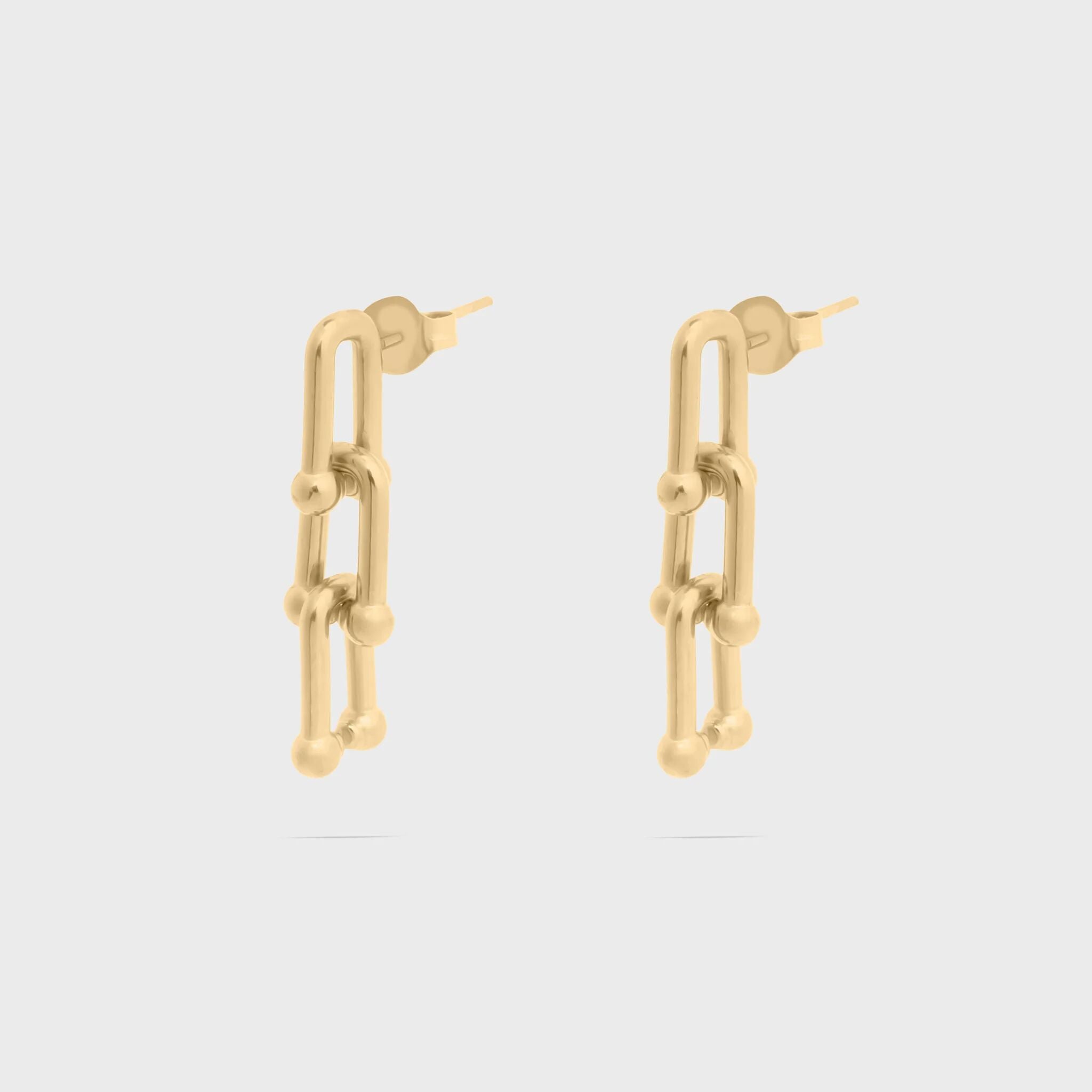 Gold chain-link earrings on a light gray background