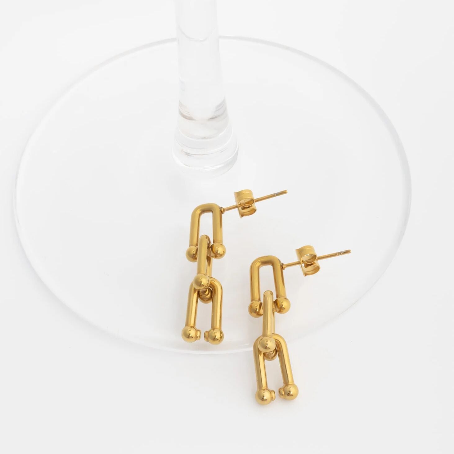 Gold abstract earrings on a white background