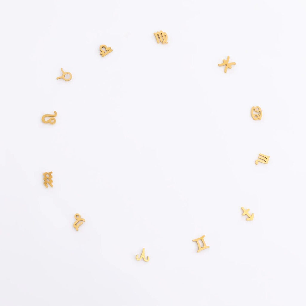 Gold zodiac earrings in a circle on a white background