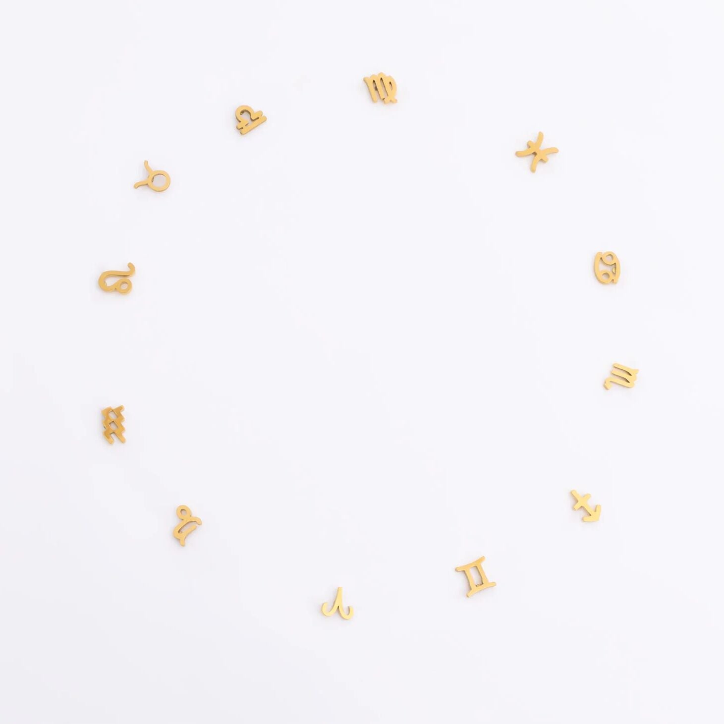 Gold zodiac earrings in a circle on a white background