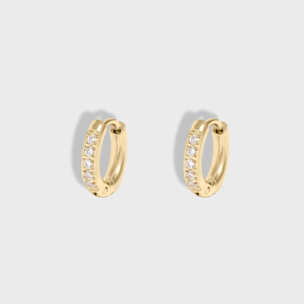 Gold hoop earrings with embedded stones on a light gray background