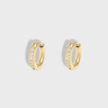 Gold hoop earrings with embedded stones on a light gray background