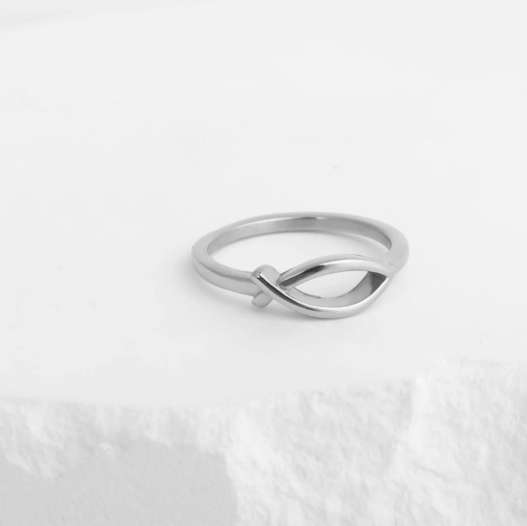 Silver ring with a unique design on a light gray background