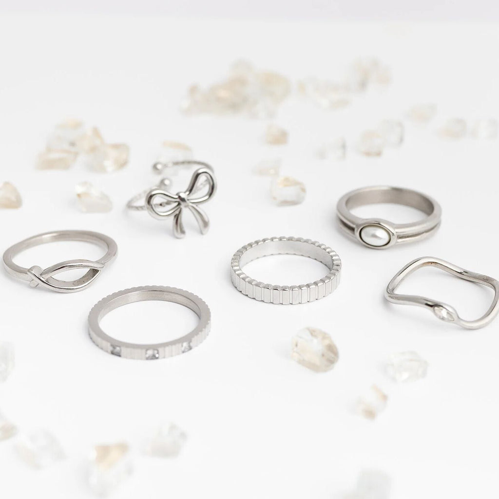 Collection of silver rings on a light background