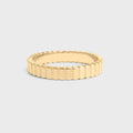 Gold ring with a textured band on a light gray background