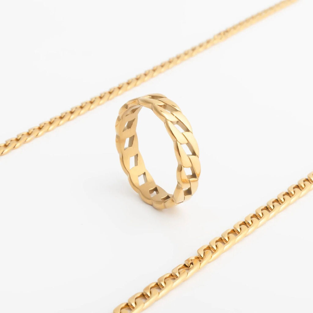 Gold ring and gold chain on a white background