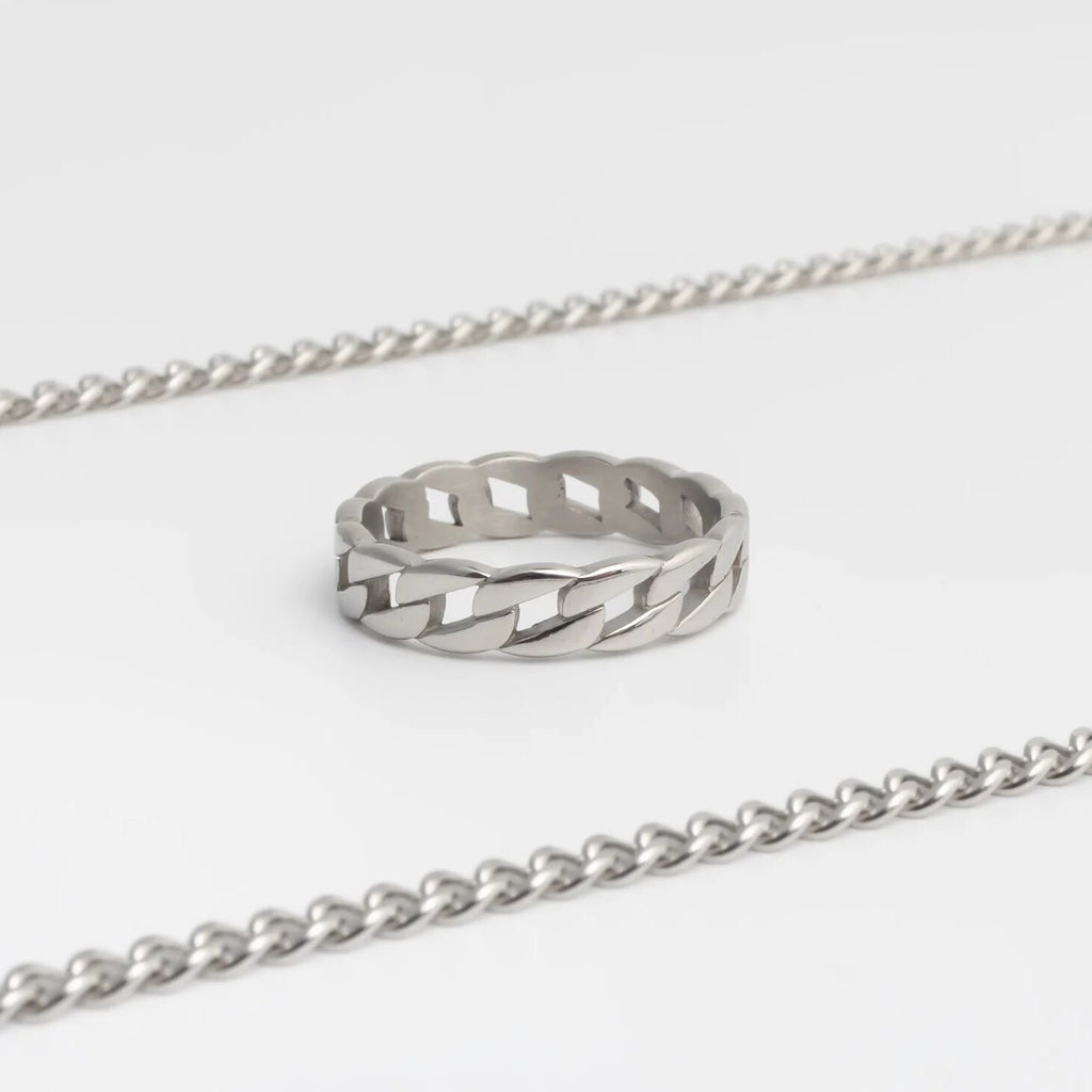 Silver ring with a textured design on a white background