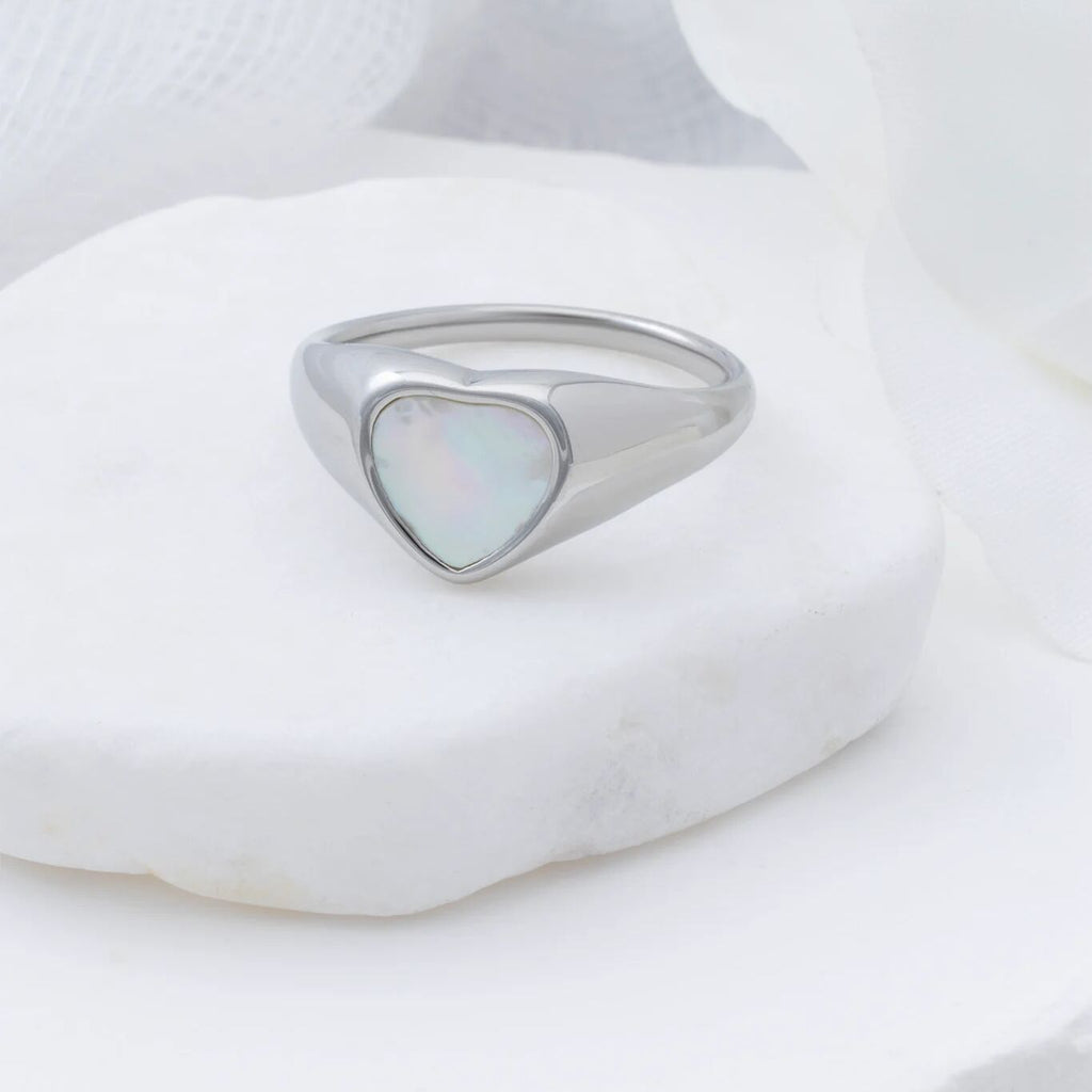 Silver ring with a heart-shaped MOP on a white background