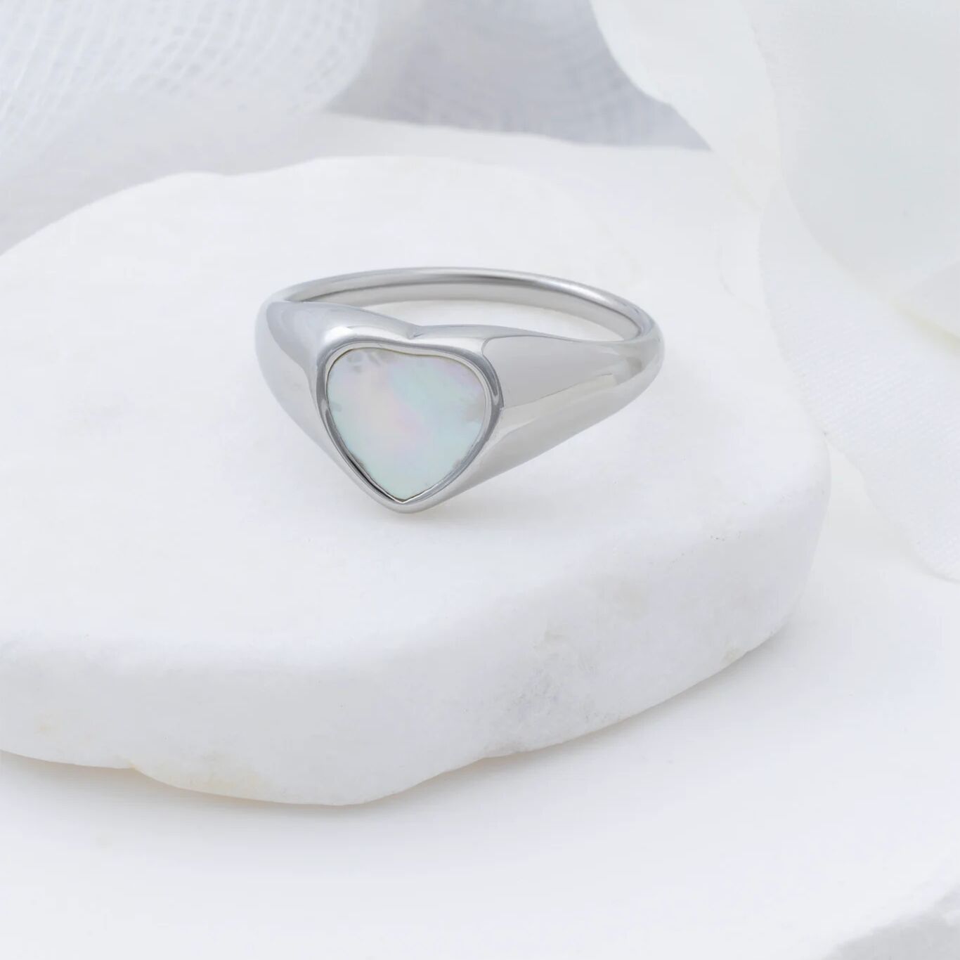 Silver ring with a heart-shaped MOP on a white background