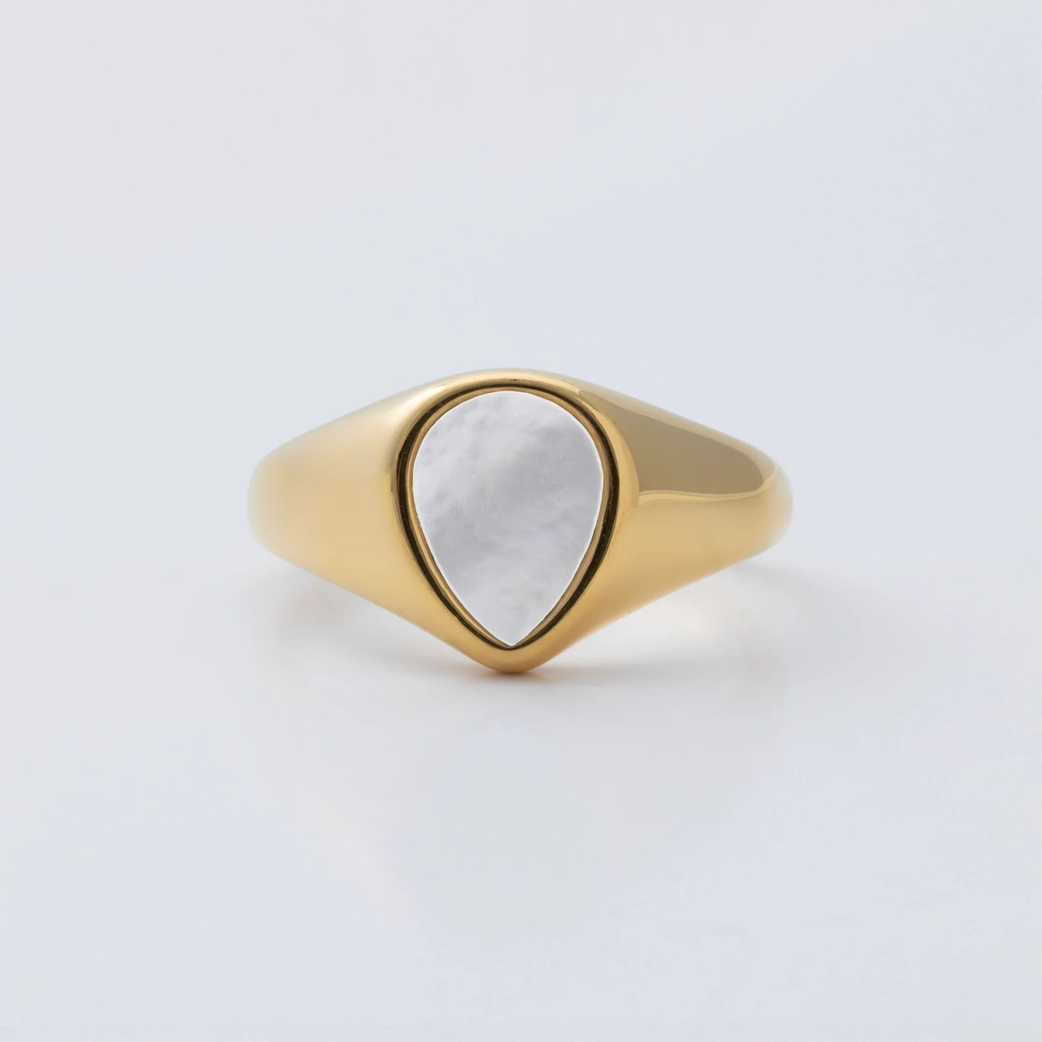 Gold ring with a MOP on a light gray background