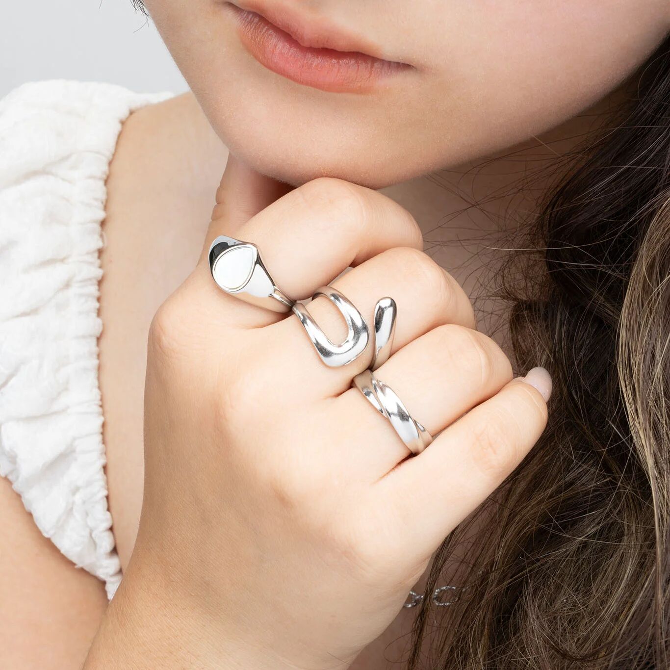 Close-up of a hand wearing three silver rings