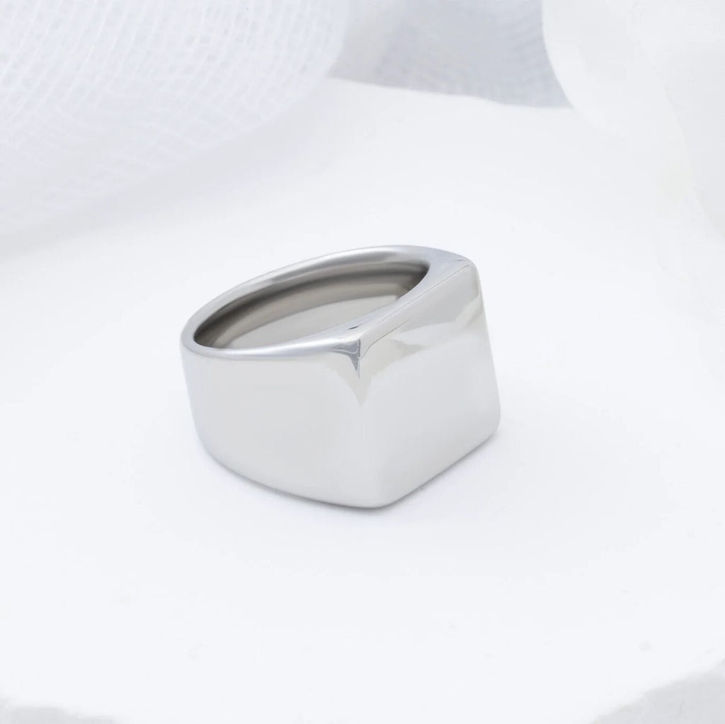 Silver square signet ring on a white background