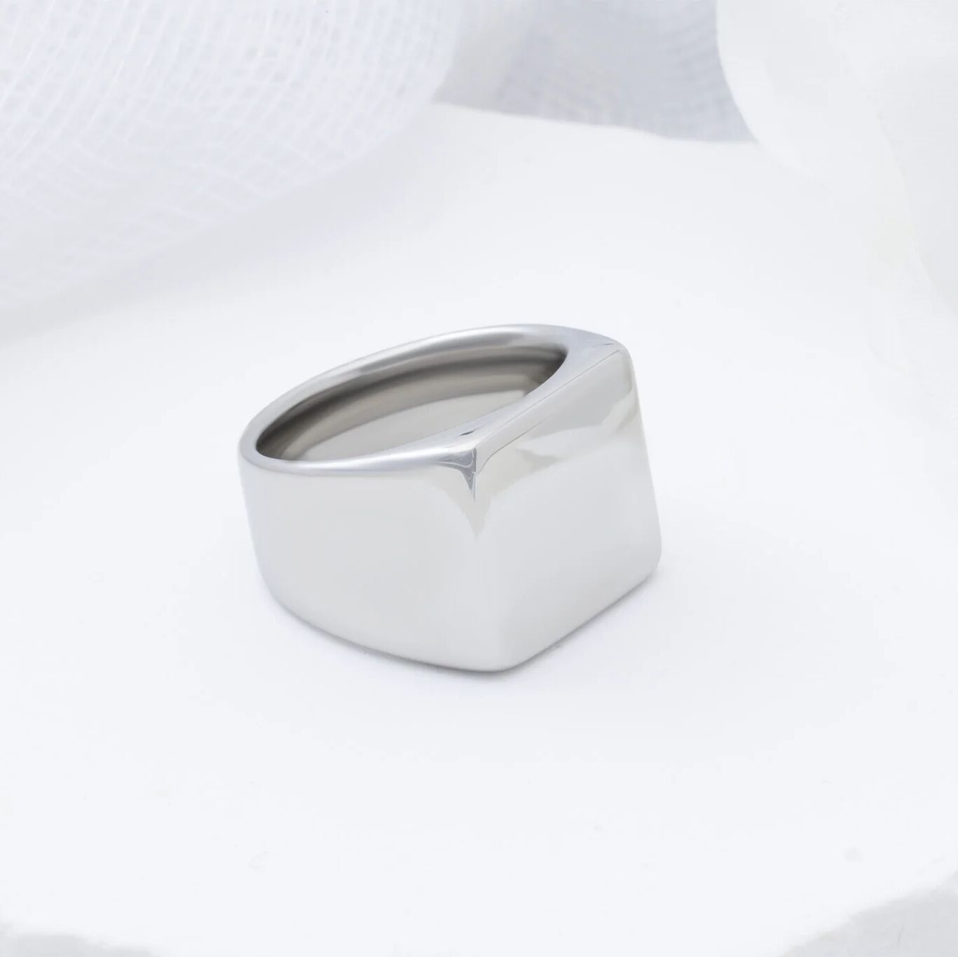 Silver square signet ring on a white background