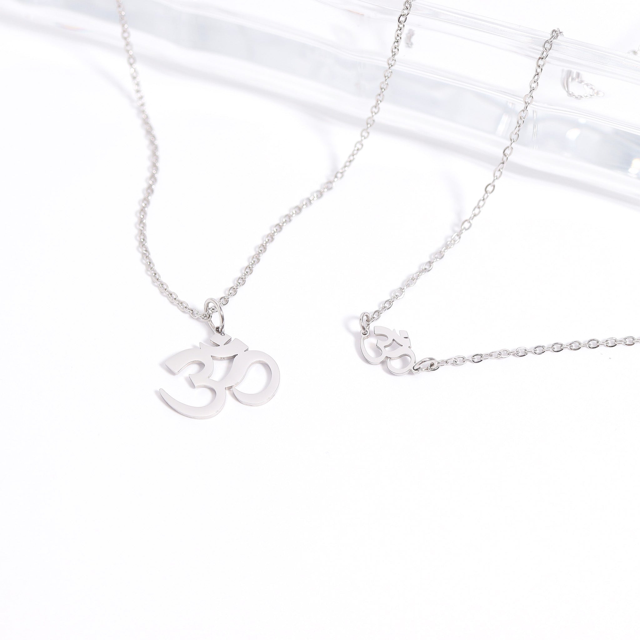 Silver necklace with Om symbol pendant on a white background