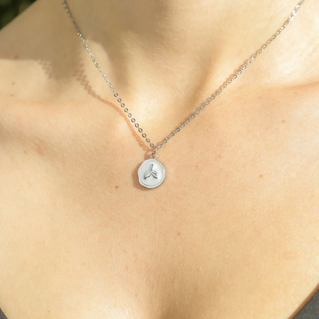 Necklace with a hexagonal pendant on a person's neck