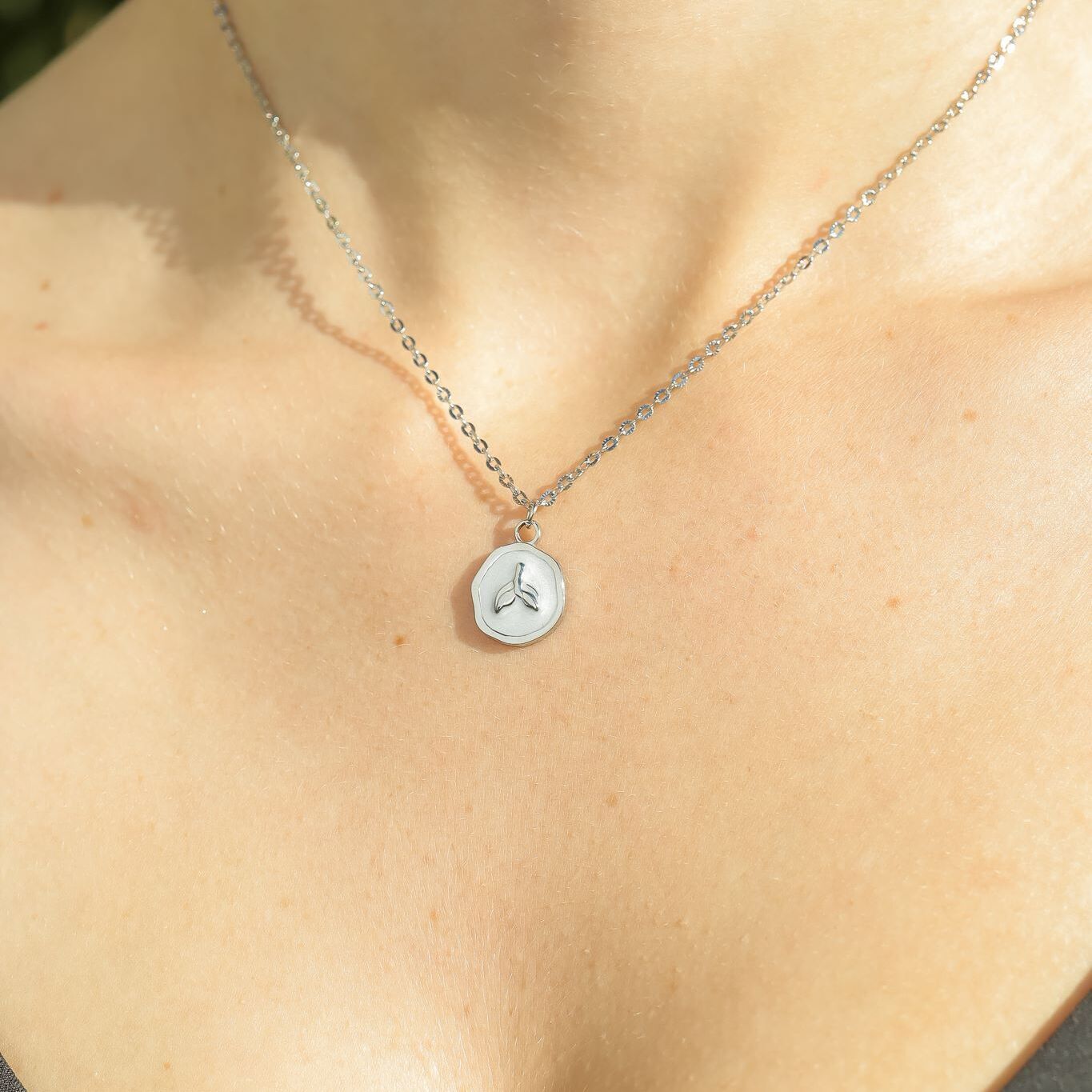 Necklace with a hexagonal pendant on a person's neck