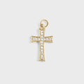 Gold cross pendant with clear stones on a light gray background