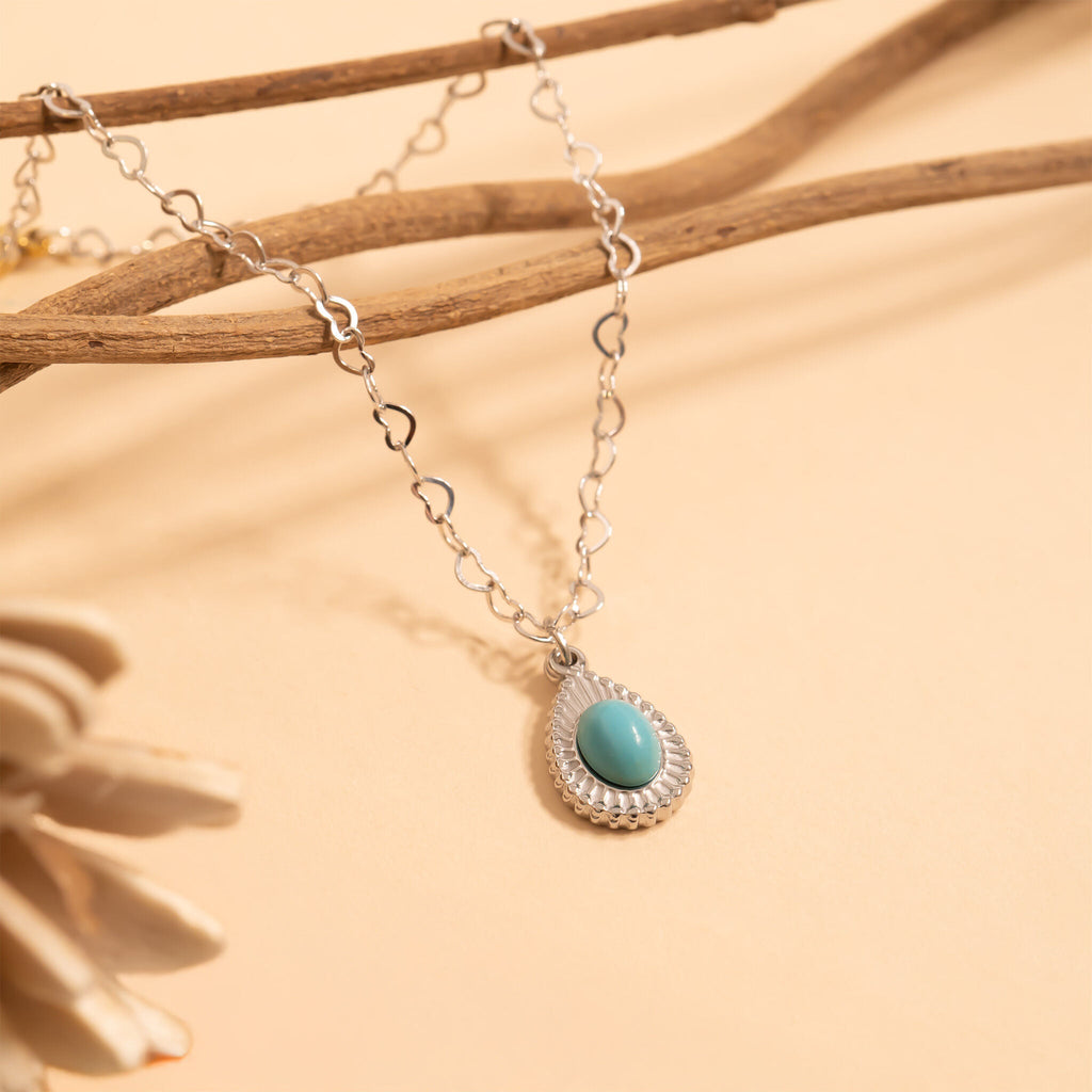 Necklace with a turquoise pendant on a beige background