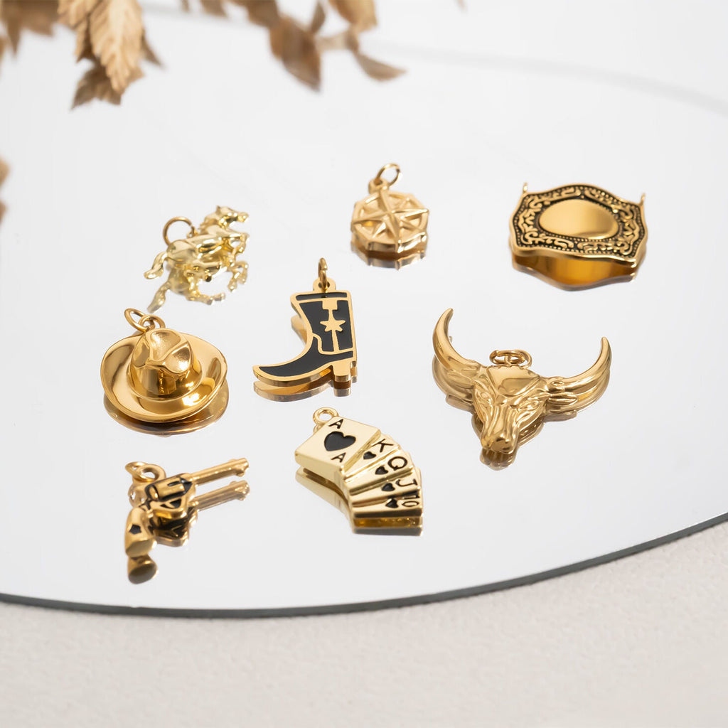 Collection of gold western pendants on a reflective surface with a neutral background