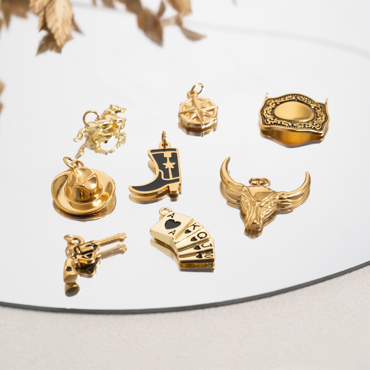Collection of gold western pendants on a reflective surface with a neutral background