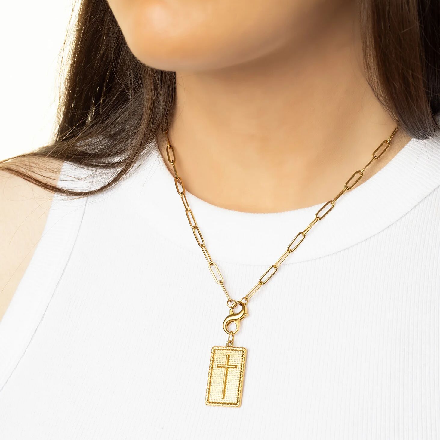 Gold chain necklace with a cross pendant on a mannequin