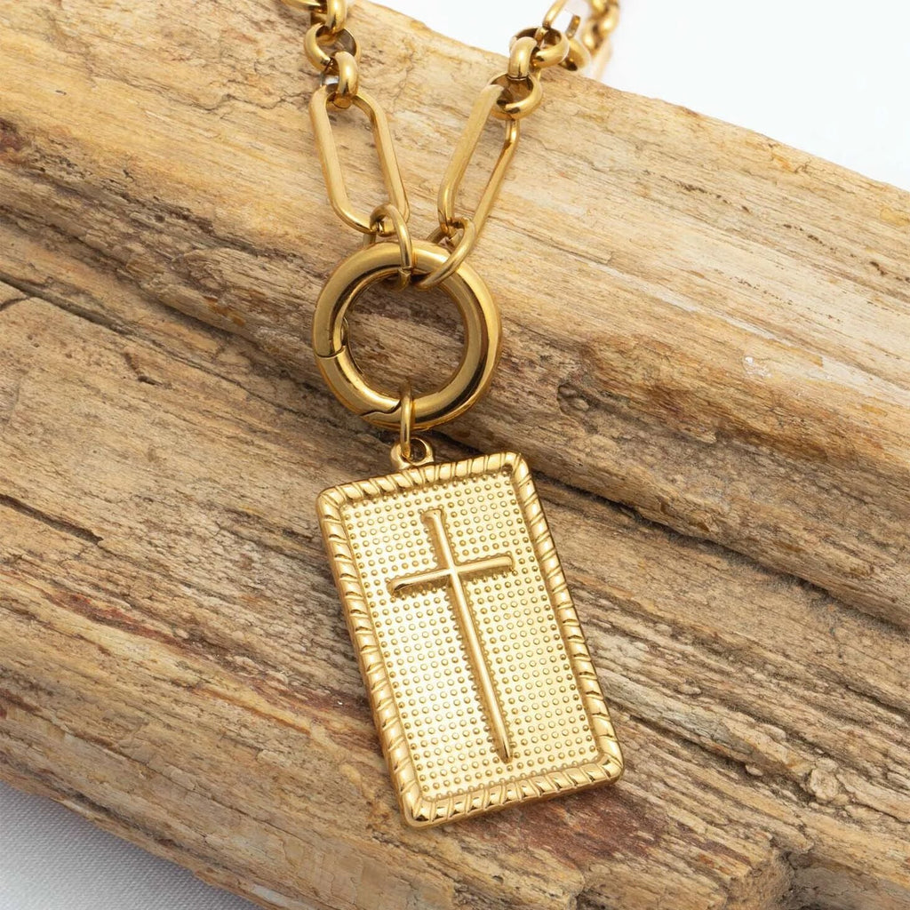 Gold necklace with a cross pendant on a wooden surface