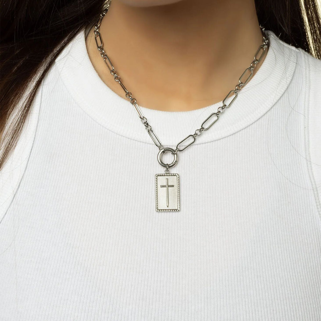 Silver necklace with a cross pendant on a white shirt