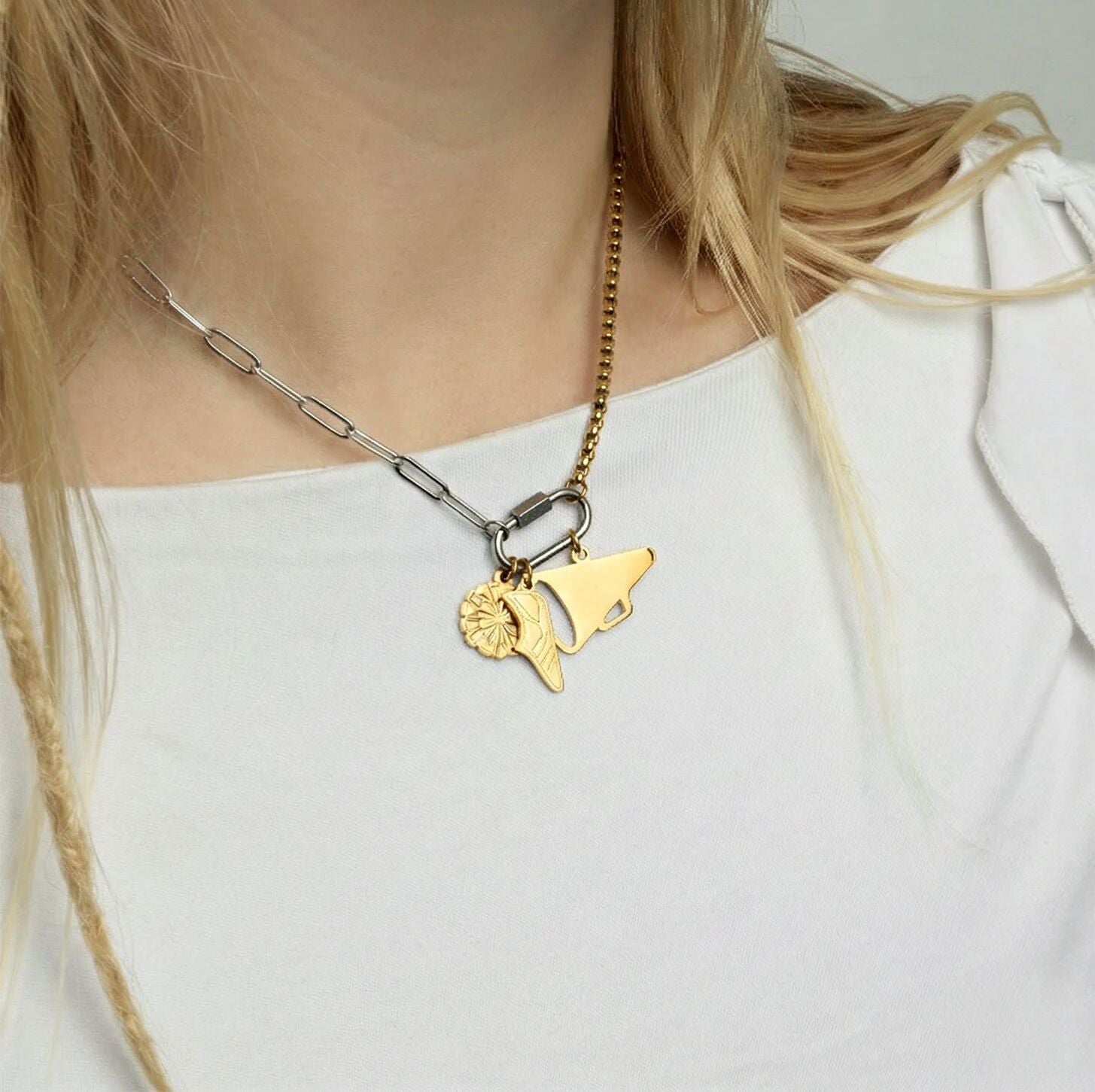 Necklace with gold charm worn by a person on a white background