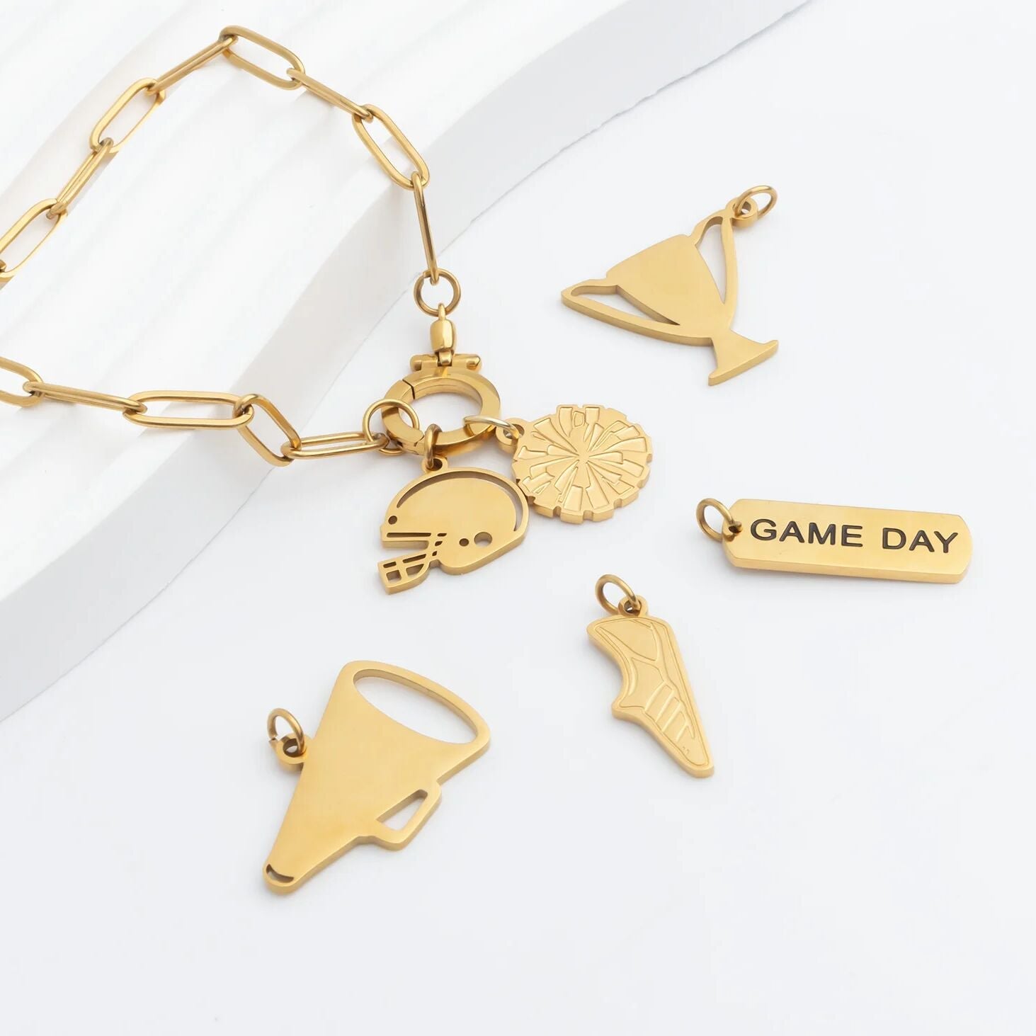 Gold bracelet with various charms on a white background