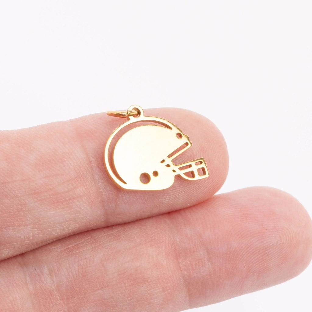 Gold helmet-shaped pendant on a hand against a white background