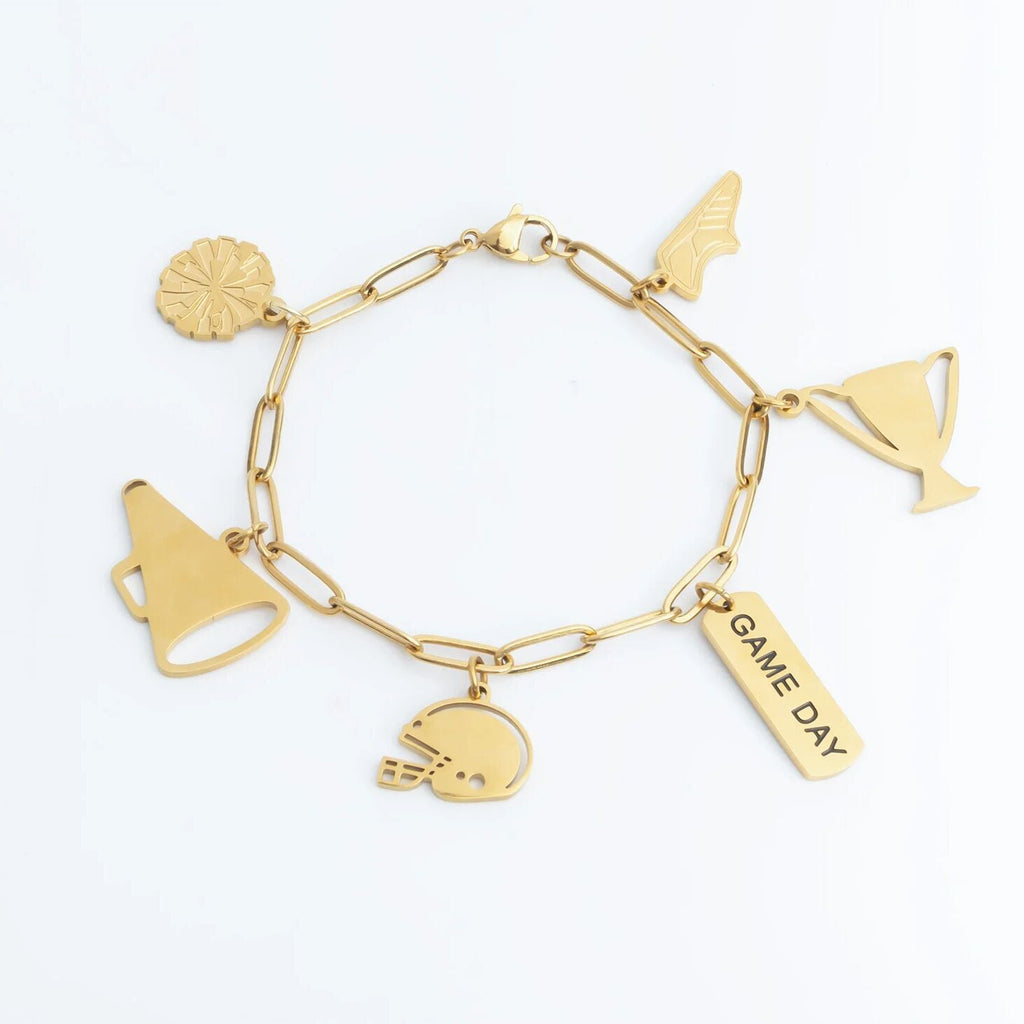 Gold charm bracelet with various charms on a white background