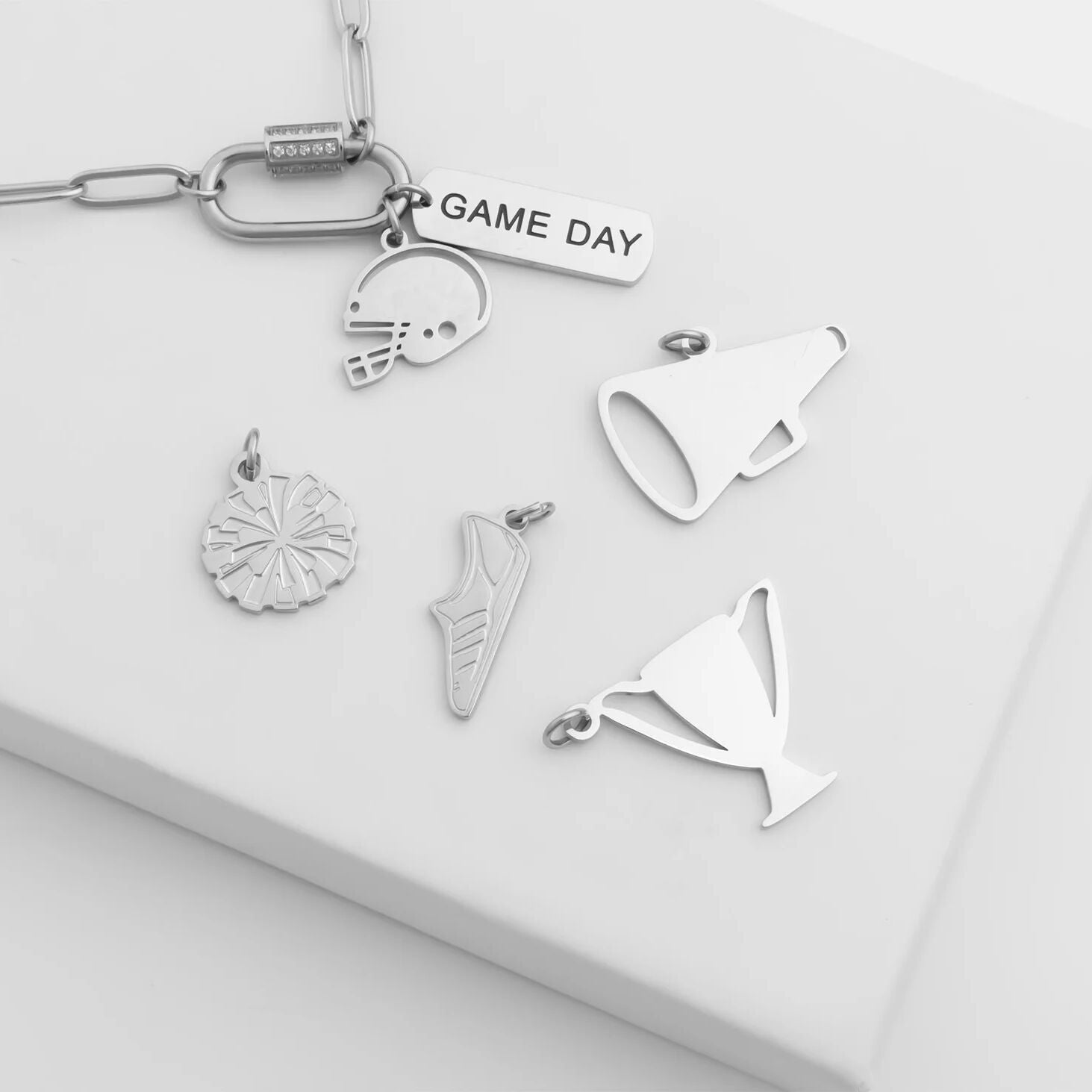 Collection of silver keychain charms on a white surface